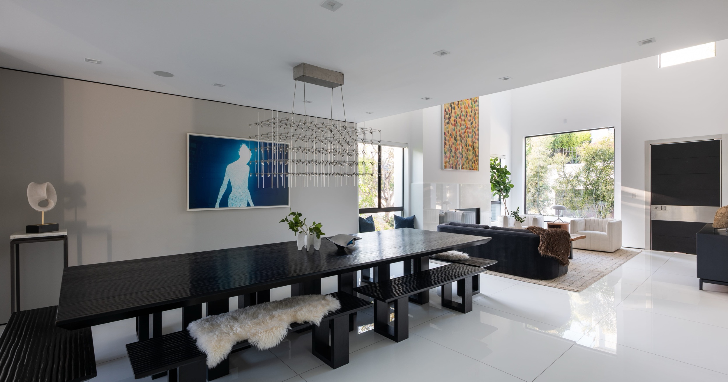 Dining table and benches with the living room and front door beyond