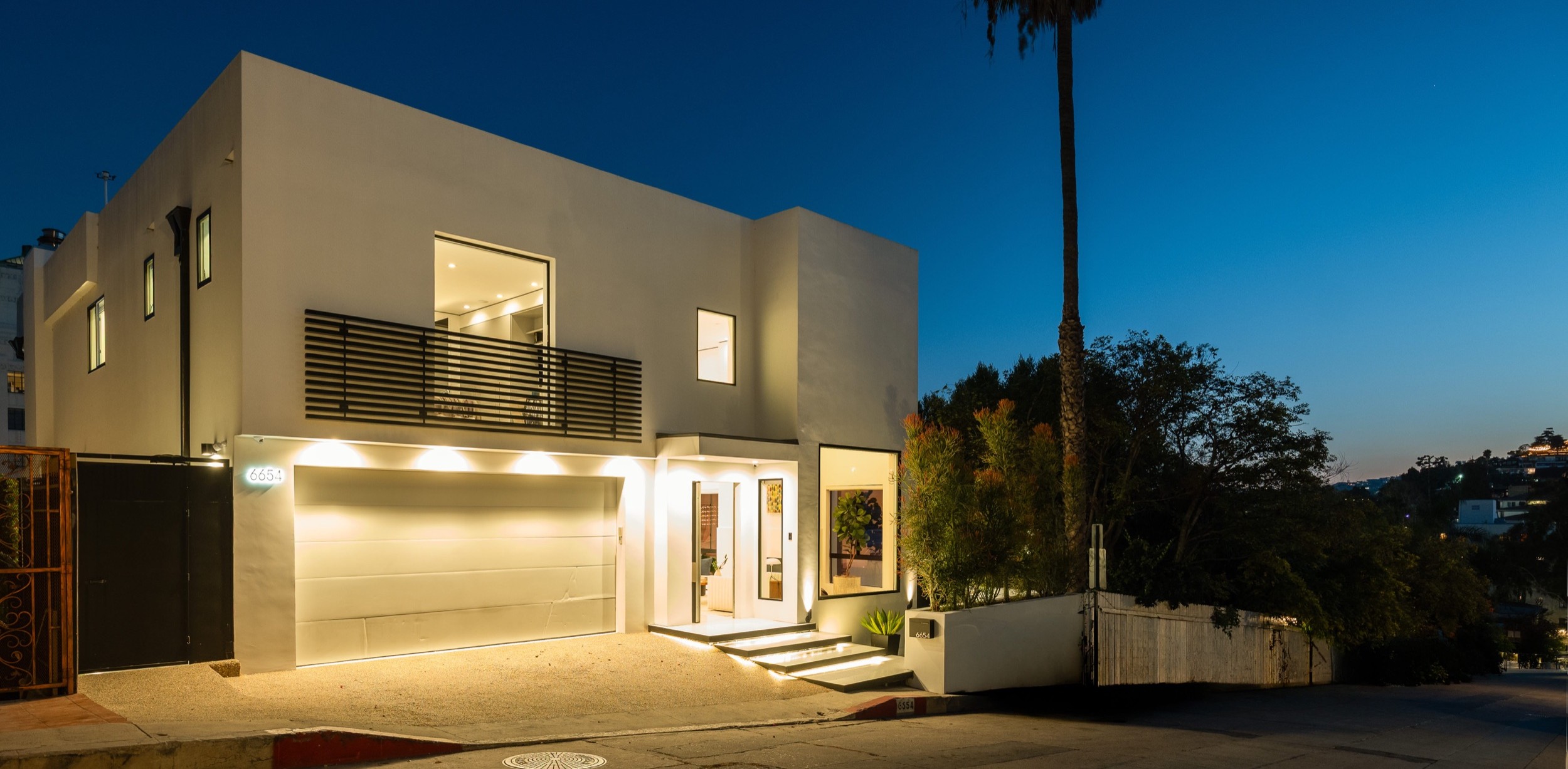 Front elevation at night with the garage and entry lit