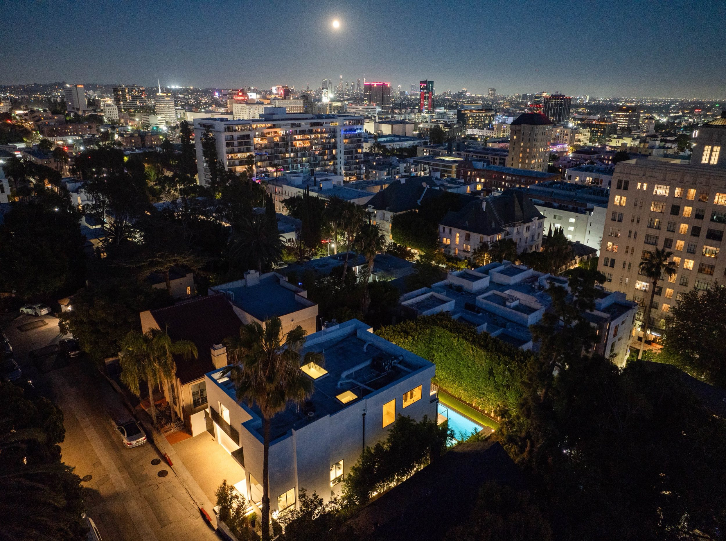 Night aerial with the lit house among the hillside and Hollywood spread beyond