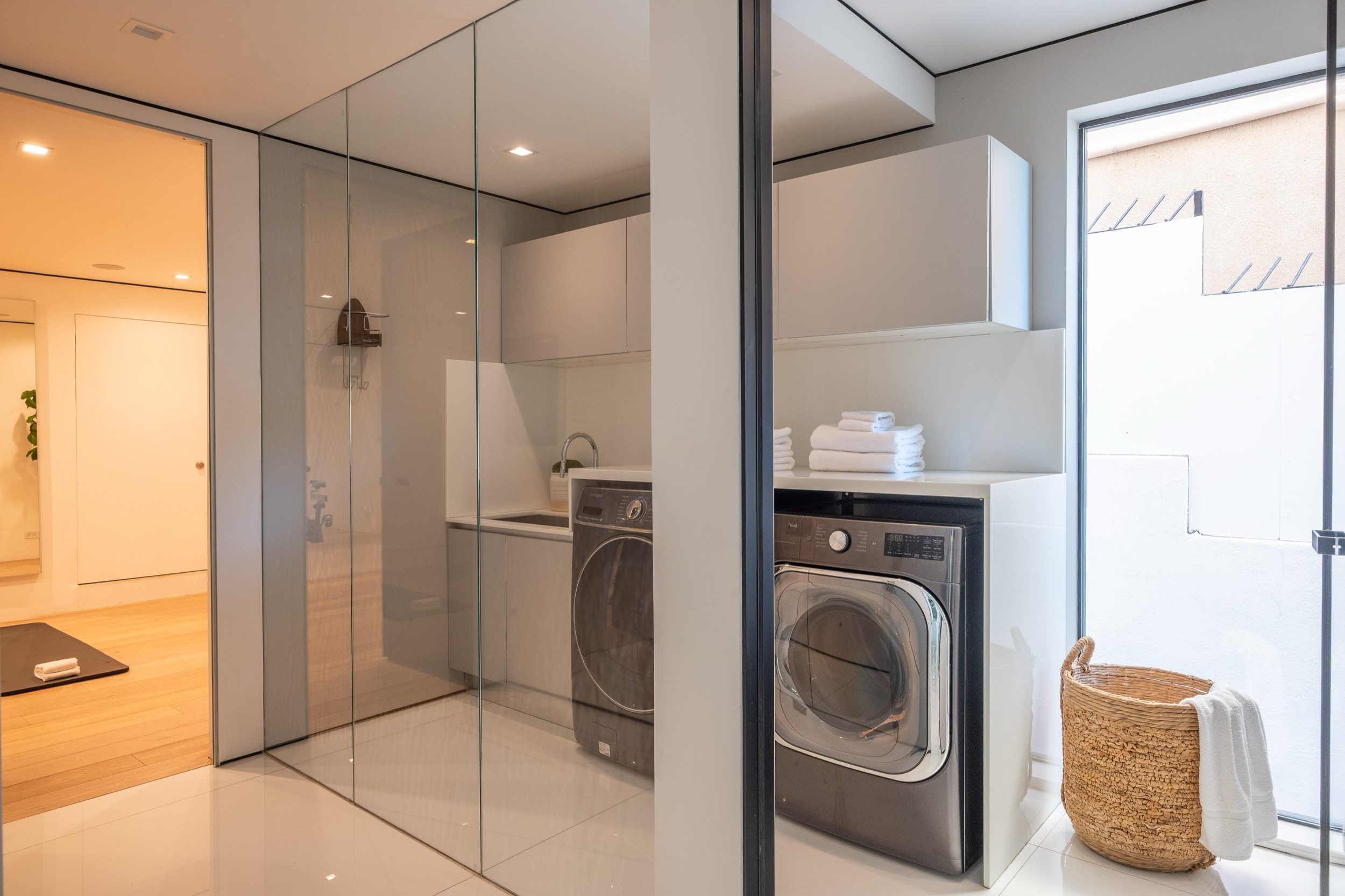 Laundry room with full size machines behind glass