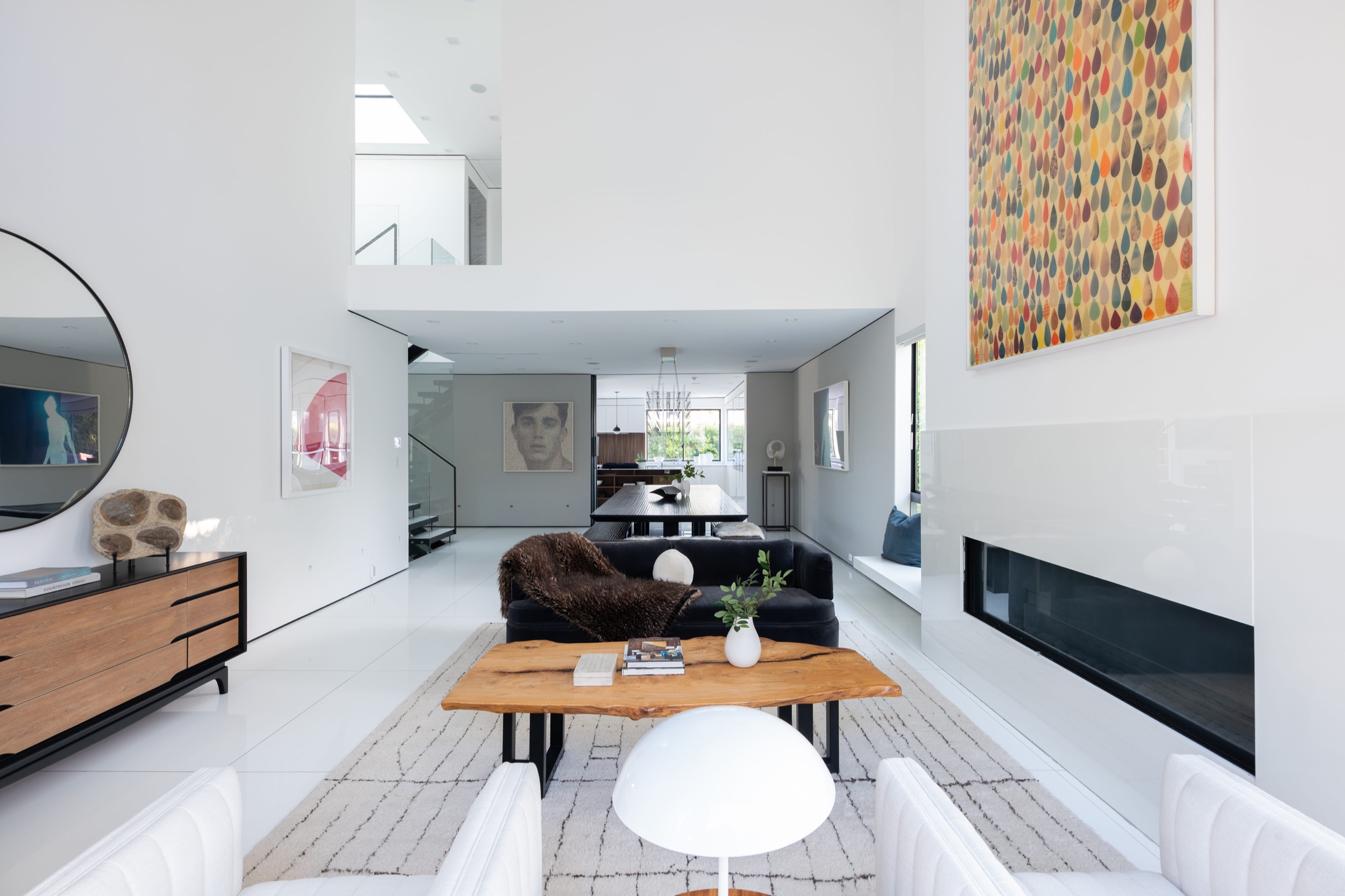 Living room from the front door, credenza and round mirror by the entry