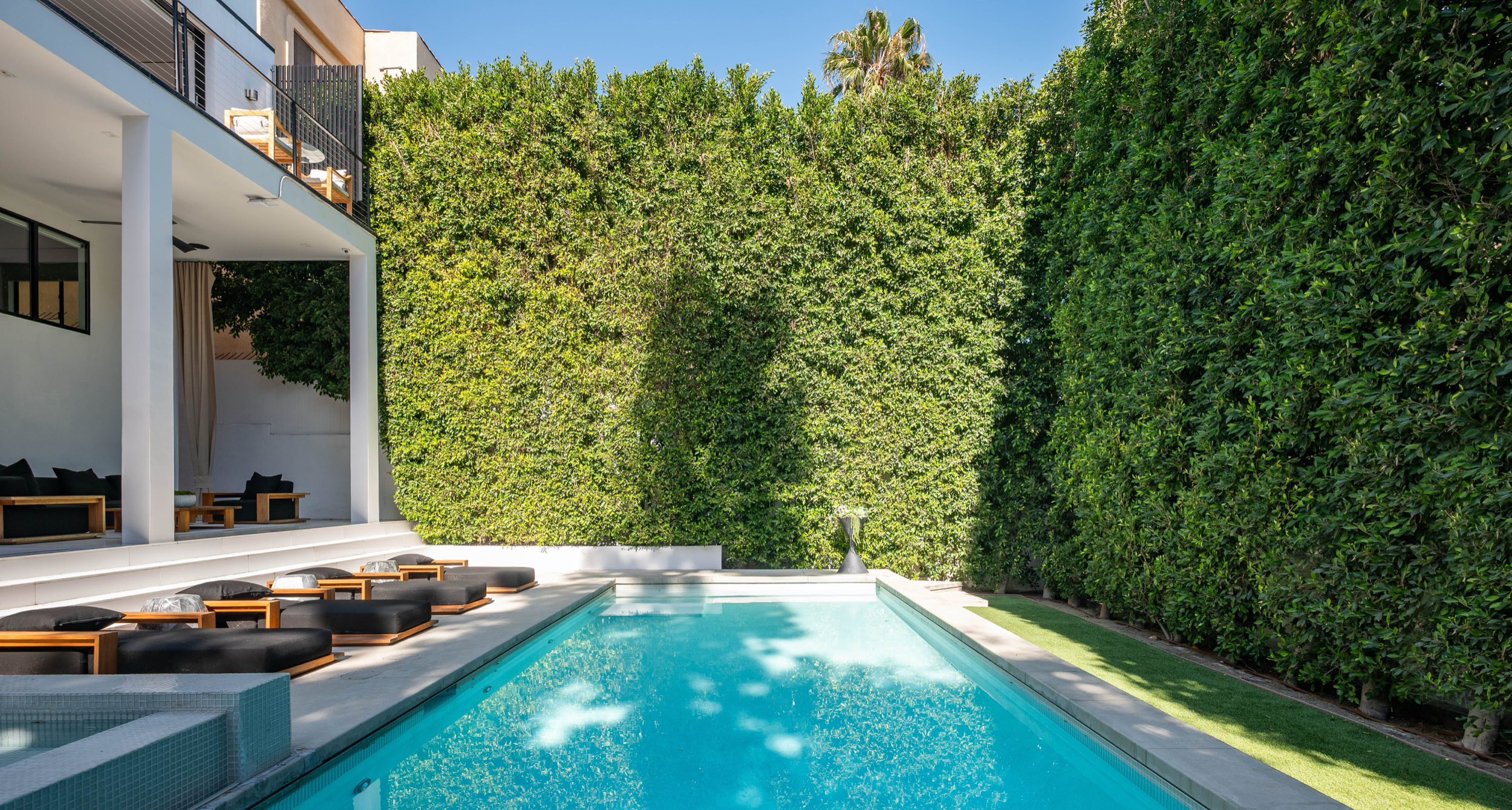 Pool and spa framed by mature hedging