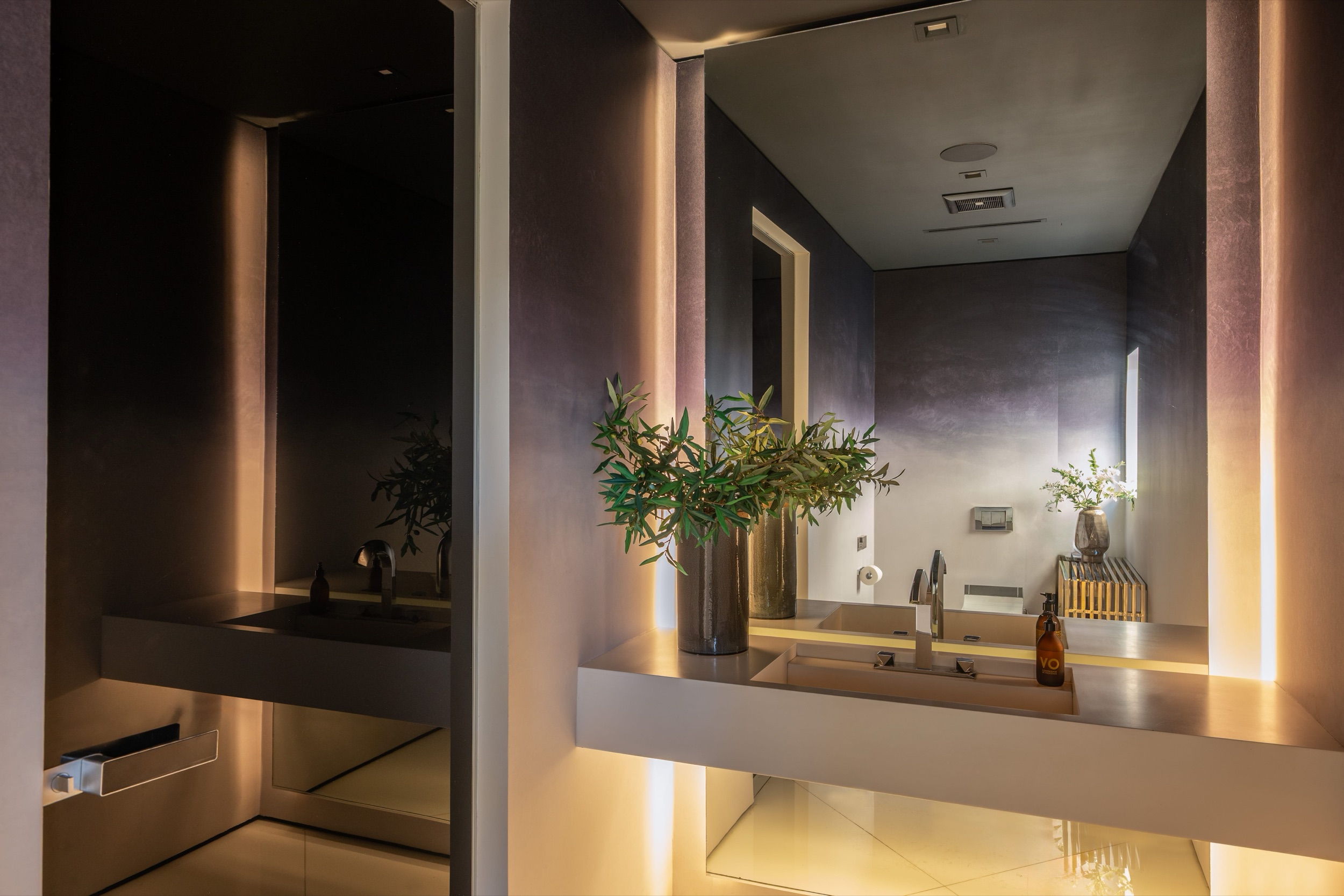 Powder room on the main level with backlit mirror and stone vanity