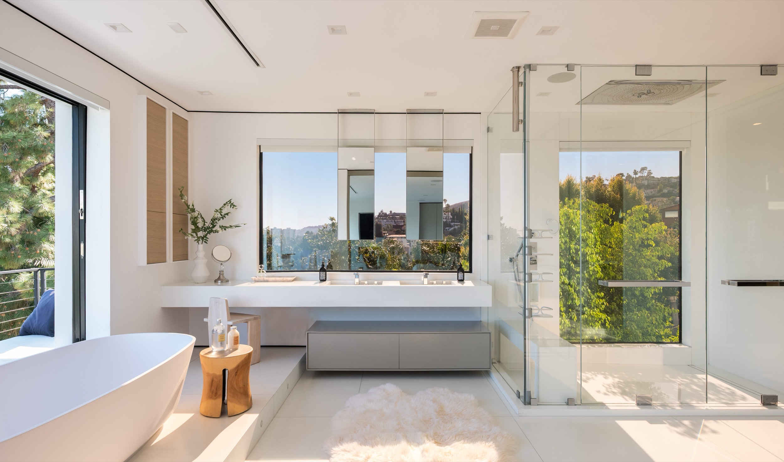Glass enclosed shower in the primary bath, dressing room through the doorway