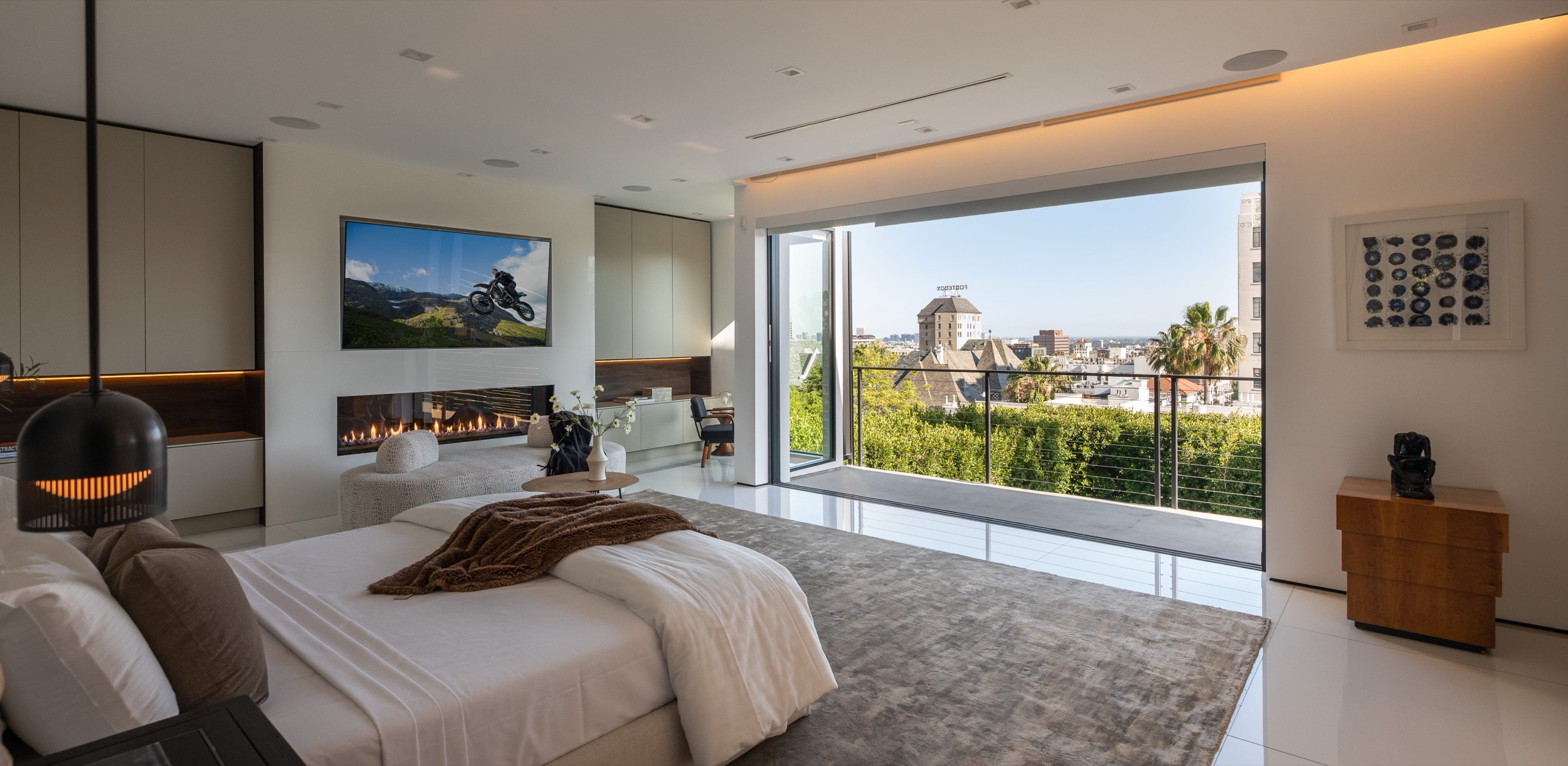 Primary suite in daylight with wall of glass to the city